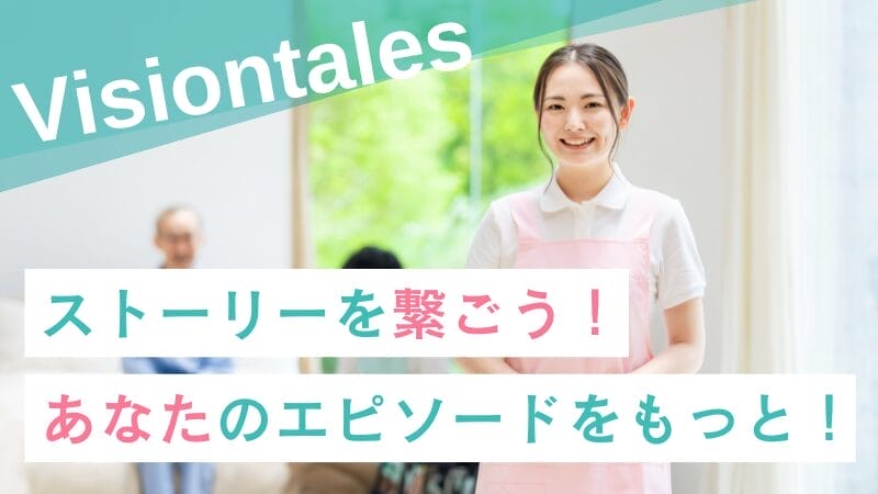 淡いピンクのエプロンを着た若い介護スタッフの女性がカメラに向かって微笑み、背景には男性介護スタッフとご利用者様2人が座っている。画像には「Visiontales」という文字と「制作」が重ねて表示されている。